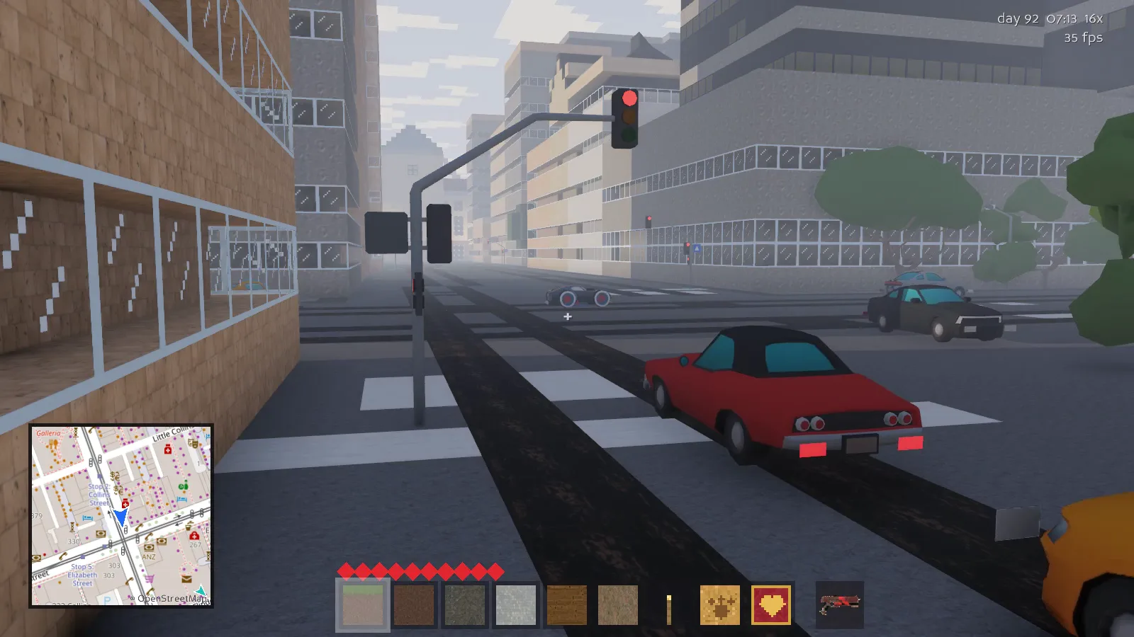 First person view at a signalled city crossing, a red coupe and a police car waiting on the red