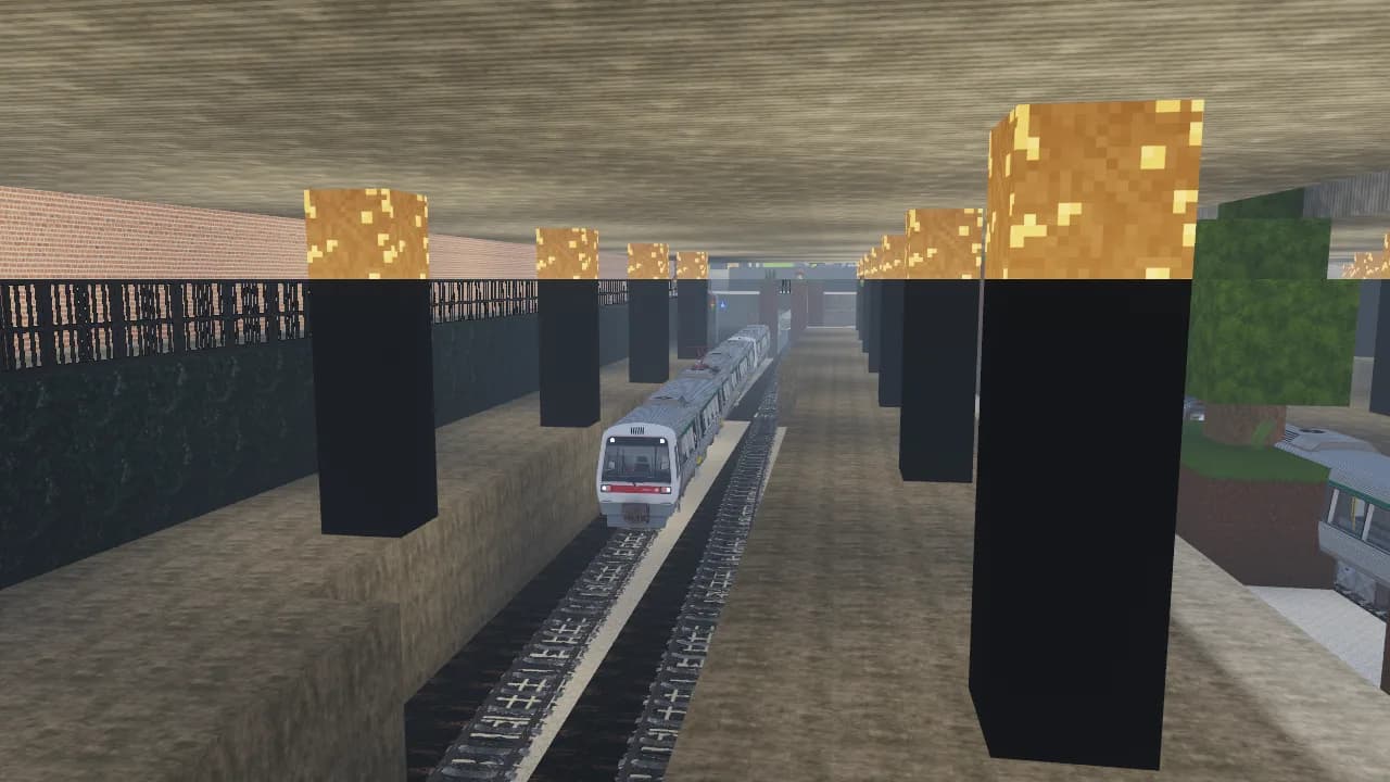 A silver train pulling into a lamp-lit platform beneath the deck at Flinders Street Station